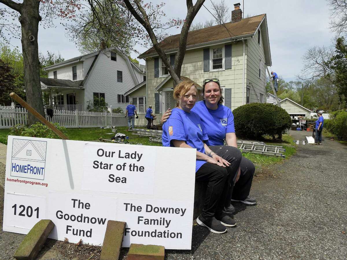 Home owner Kathleen Kinsella is photographed on May 5, 2018 with Emma Wiegand as volunteers work on much needed home improvement projects to her home in Stamford, Connecticut. About 30 volunteers from Our Lady Star of the Sea made improvements to Kinsella's1930 Colonial home, as part of HomeFront Day, in which volunteers revitalize homes for low-income families. Among other things, beneficiaries eagerly await having drafty windows replaced and tired walls painted, along with plumbing and electrical improvements, roofing repairs, wheel chair ramp installations and other safety enhancements. HomeFront is a Stamford-based non-profit whose community-based programs provide quality of life improvements to families with financial hardships.