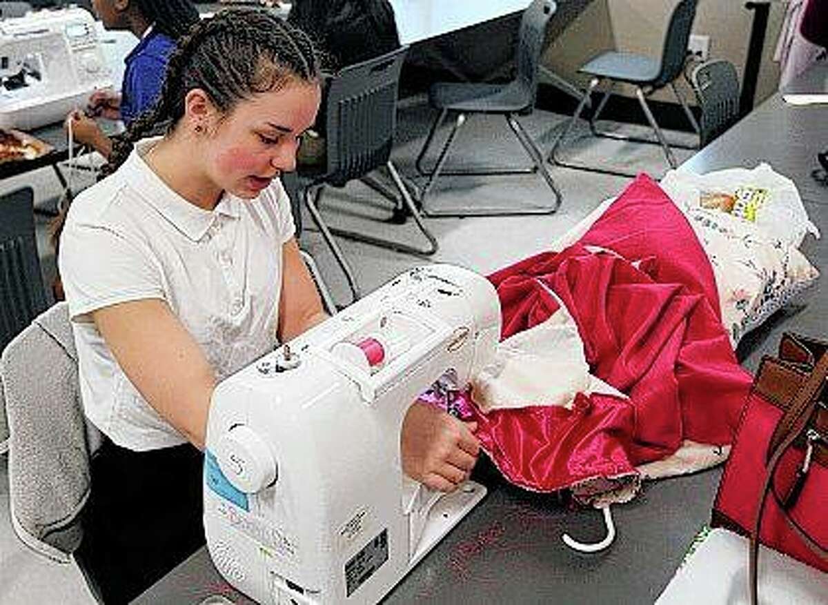 Student Brigid Duesterhaus operates a sewing machine while making her own prom dress during a sewing class at MacArthur High School in Decatur. “I just love fashion and designing,” Duesterhaus said.