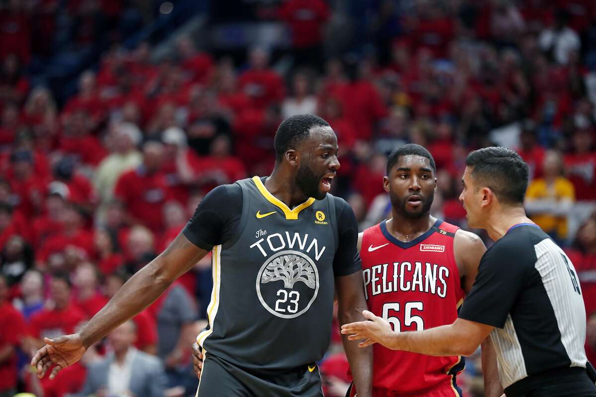 Golden State Warriors forward Draymond Green (23) challenges an official in front of New Orleans Pelicans forward E'Twaun Moore (55) in the first half of Game 4 of a second-round NBA basketball playoff series in New Orleans, Sunday, May 6, 2018. (AP Photo/Gerald Herbert)