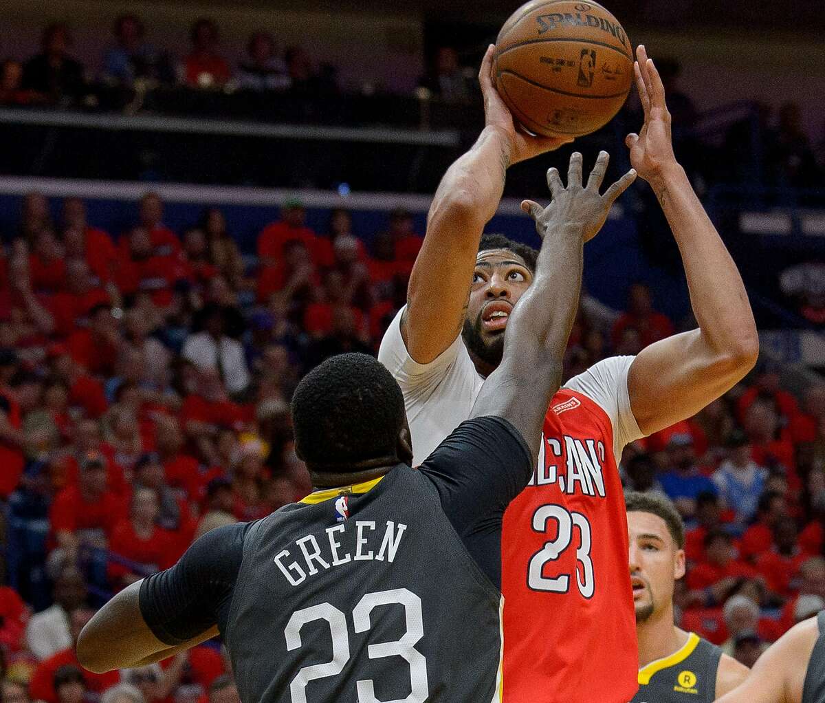 New Orleans Pelicans forward Anthony Davis (23) shoots against Golden State Warriors forward Draymond Green (23) during the first half of game 4 of the conference semifinal NBA playoffs at the Smoothie King Center in New Orleans, La. Sunday, May 6, 2018.