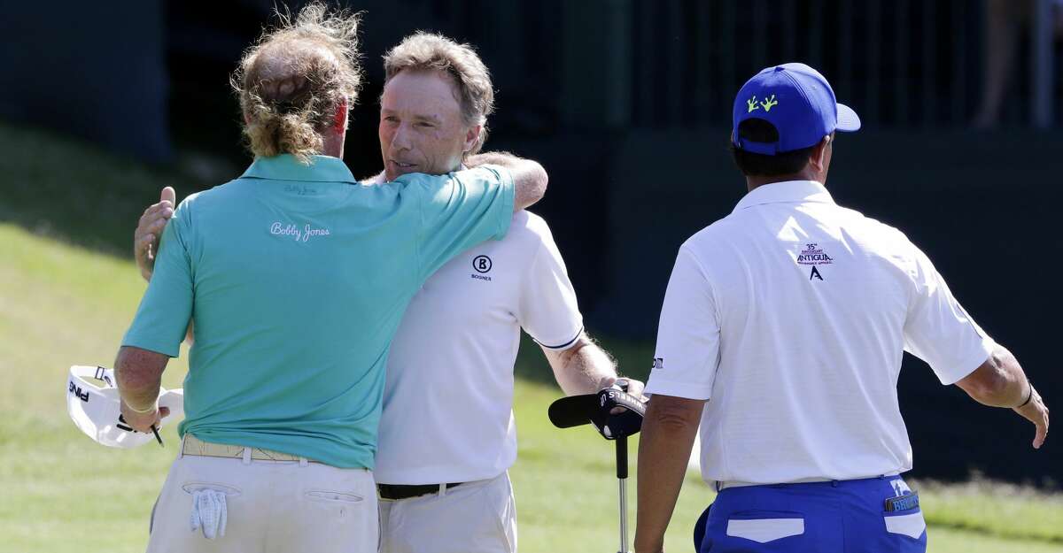 Bernhard Langer, center, hugs his playing partners Miguel Angel Jimenez, left, and Tom Pernice Jr. on the 18th green after Langer won the Insperity Invitational at the The Woodlands Country Club Sunday, May 6, 2018, in The Woodlands, TX. (Michael Wyke / For the Chronicle)