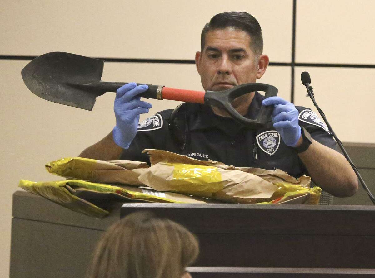 Crime scene investigator Joe Rodriguez examines a shovel that was in an evidence bag Tuesday May 8, 2018 in the 186th state District Court during the trial of Gregorio Barrera. Gregorio Barrera is accused of killing his younger brother Andres Barrera and then burying him.