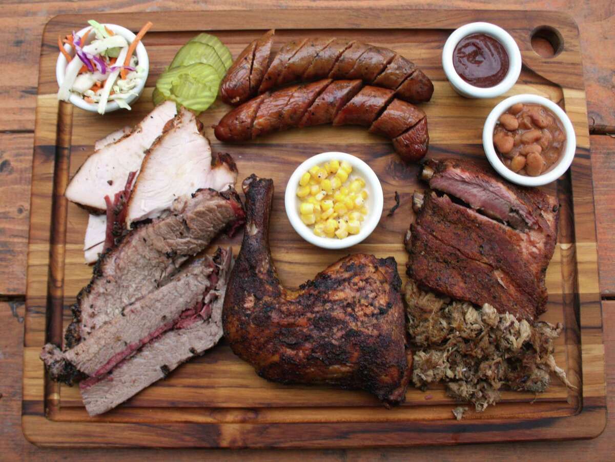 The board at B-Daddy's BBQ includes (clockwise from top left) cole slaw, regular and jalapeño sausage, sauce, beans, pork loin spare ribs, pulled pork, chicken quarter, creamed corn, brisket and turkey.