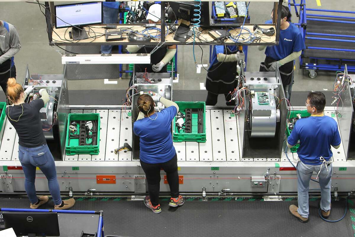 Workers assemble air conditioning units in the new Daikin facility Wednesday, May 10, 2017, in Waller before it officially opens on May 24. It is the world's largest building of this particular construction type (called "tilt-wall"). It's four million square feet, about the size of 40 city blocks, or 91 acres. The plant bring several thousand manufacturing jobs to Houston when it opens. They make air conditioning, heating and ventilation units. ( Steve Gonzales / Houston Chronicle )