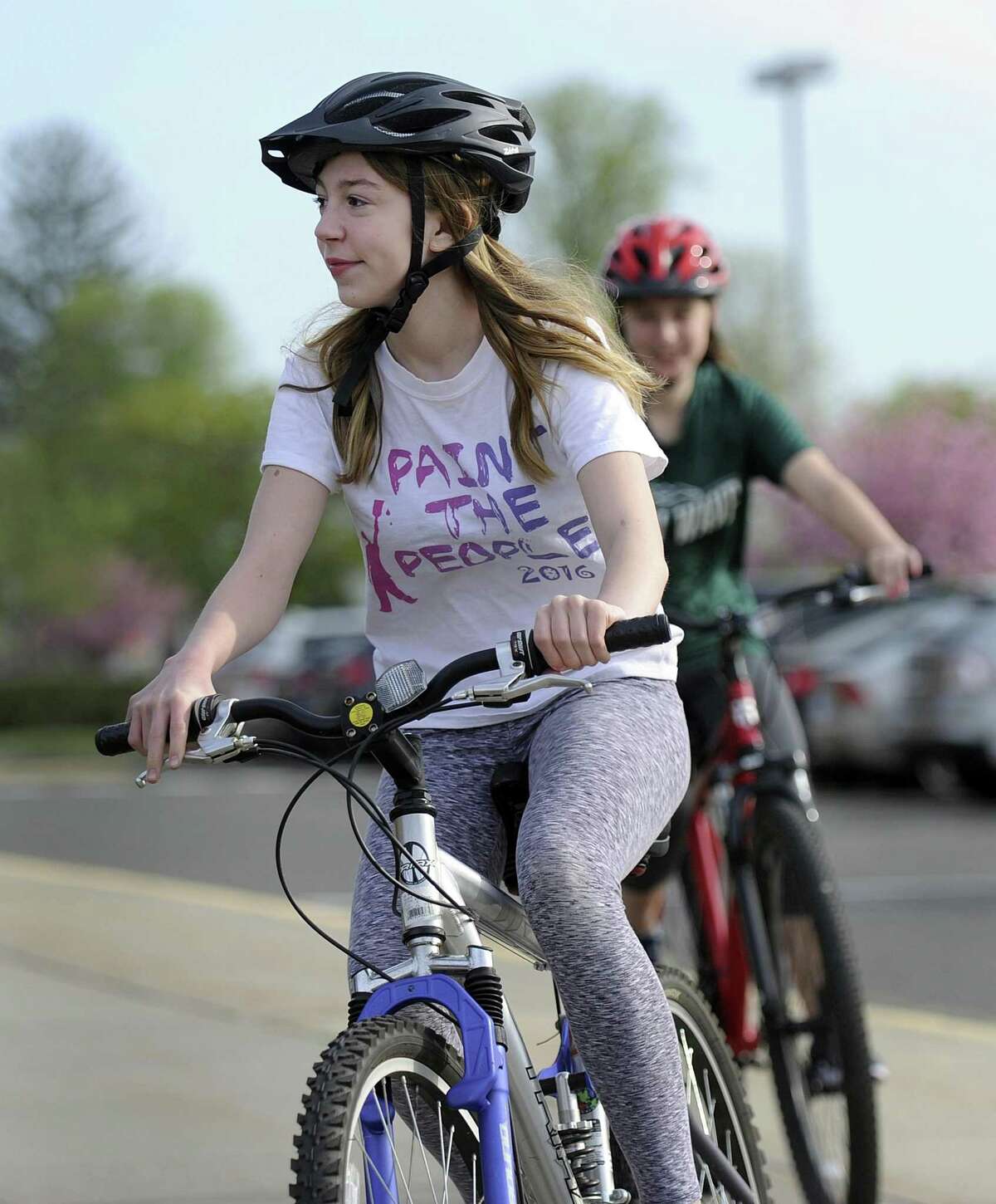 Kati Seppa, 14, and Lilian Viti, 15, behind her, ride bicycles around New Milford High School Monday morning, May 7, 2018. The school started a new bike safety initiative where students learn these skills in gym class.