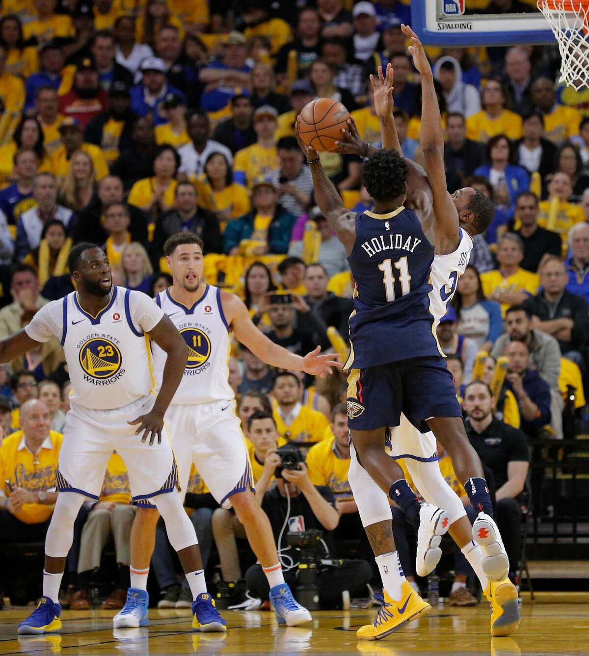 New Orleans Pelicans' Jrue Holiday is fouled by Golden State Warriors' Kevin Durant in the second quarter during game 5 of the Western Conference Semifinals between the Golden State Warriors and the New Orleans Pelicans at Oracle Arena on Tuesday, May 8, 2018 in Oakland, Calif.