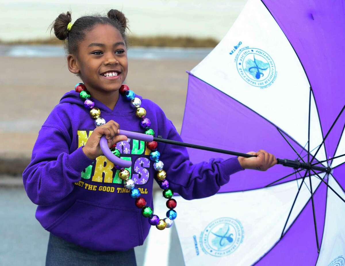 Unique Burnom, 8 years old of Dallas, plays with an umbreslla as it is drizzling to watch the Krewe dÂ?’Esprit Rosaire Parade on Seawall Boulevard on Saturday, Feb. 10, 2018, in Galveston. ( Yi-Chin Lee / Houston Chronicle )