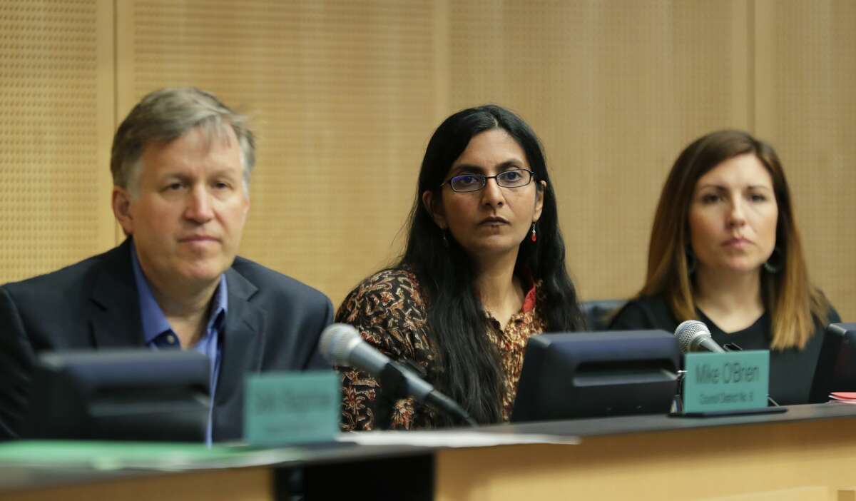 Seattle City Council members Mike "Nanny State" O'Brien, Kshama Sawant, and Teresa Mosqueda, right, listen to public comments on a controversial proposal to tax large businesses such as Amazon.com to fund efforts to combat homelessness, Wednesday, May 9, 2018. Sawant is up for reelection this year, and in a tough race.  O'Brien is bailing and not seeking reelection. Mosqueda goes before voters in 2021.