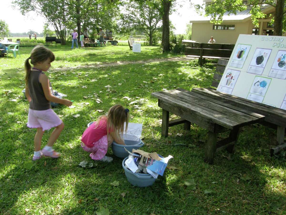 Liliana Molis, on the left, and Ava Molis, on the right, practice recycling by playing the game Ã©¢??DonÃ©¢??t trash your materialÃ©¢?Â at the Earth Day Celebration April 25 at Armand Bayou Nature Center.
