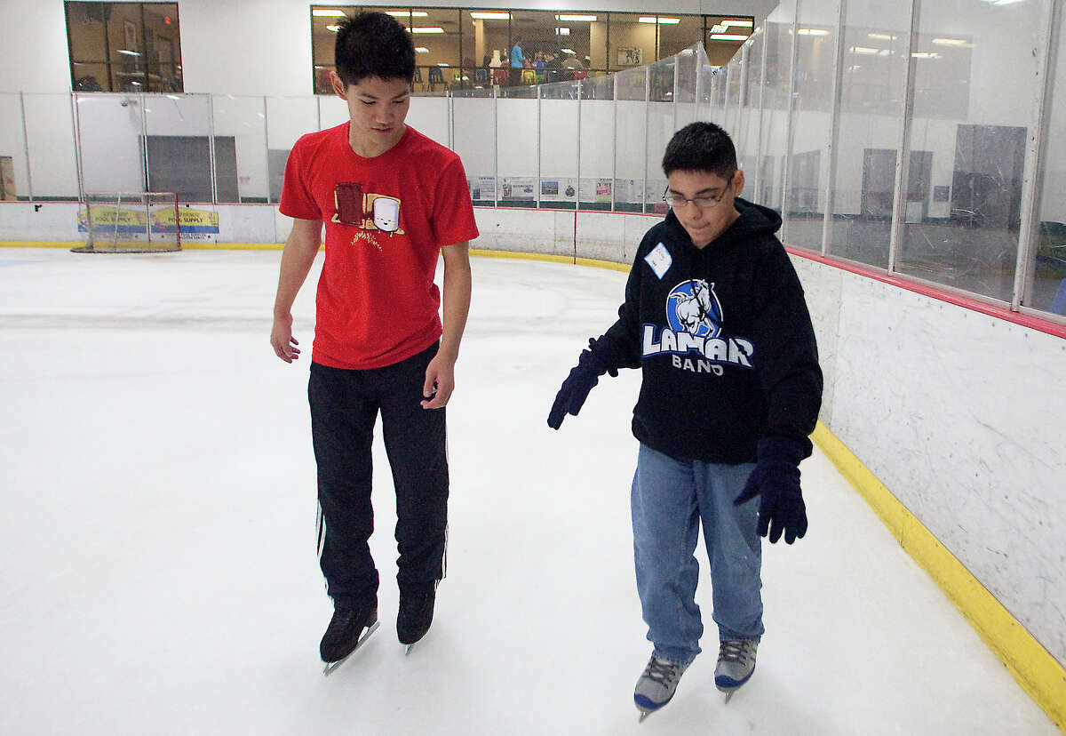 Sugar Land Ice and Sports Center's Joseph Lee, left, insructs Eloy Diaz.