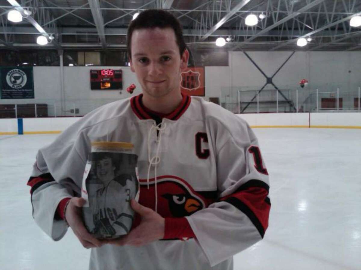 Greenwich High captain Rit Spezzano holds a donation with a picture of paralyzed hockey player Matt Brown. The GHS hockey team has raised $27,000 for Brown.