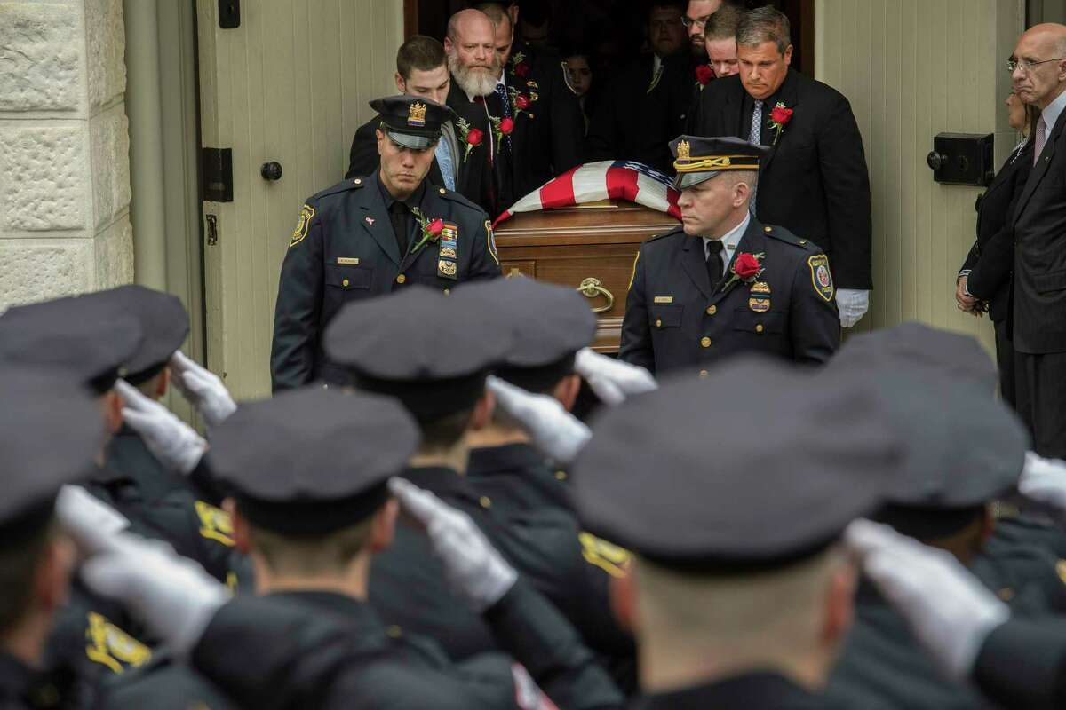 The casket with the remains of Detective Jason Martin leaves St. Mary's Church as the members of the Albany Police Department salute Thursday May 10, 2018 in Albany, N.Y. Detective Martin died of cancer. (Skip Dickstein/Times Union)