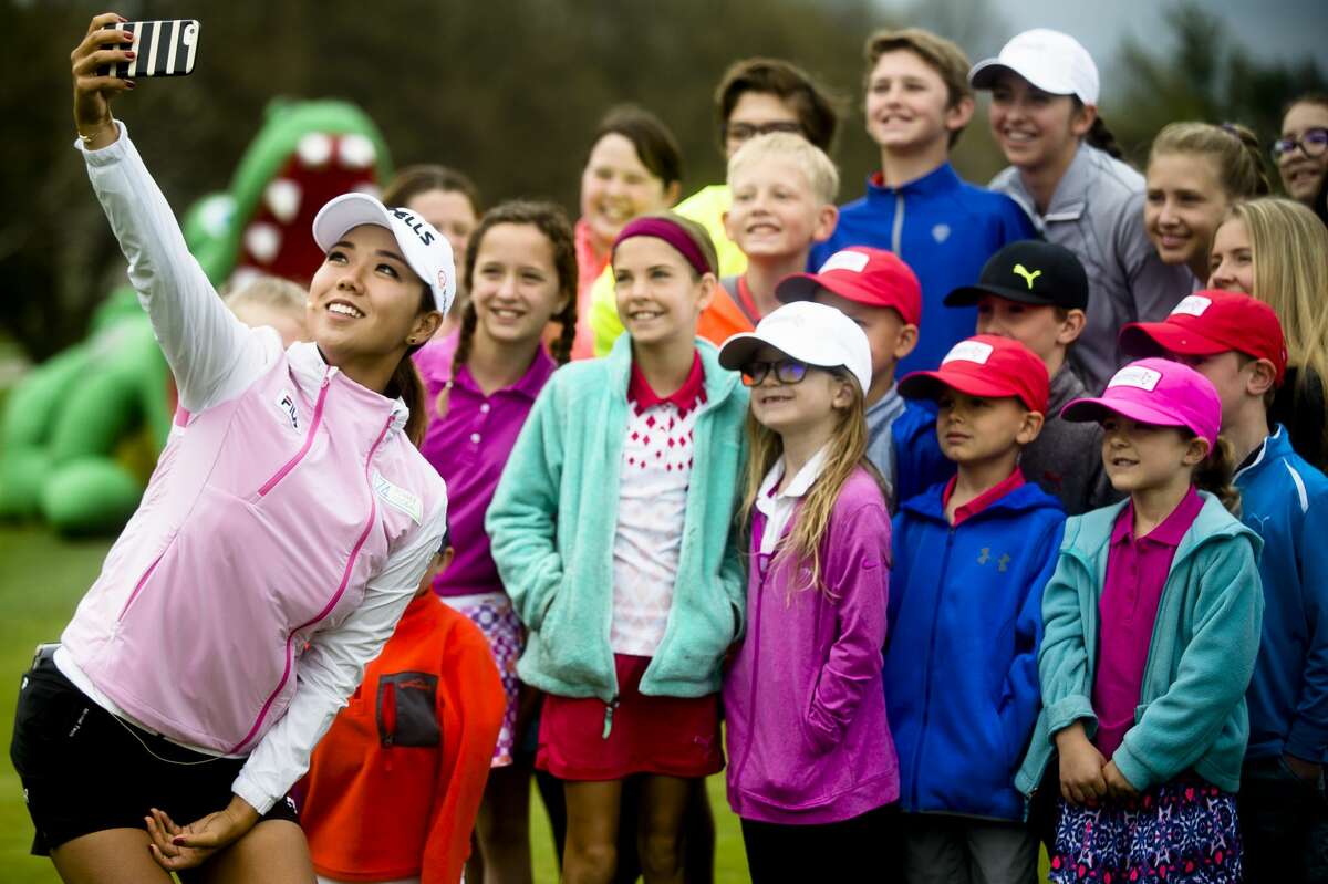 LPGA golfer Jenny Shin takes a selfie with a group of children after helping them work on their form during a clinic on Thursday, May 10, 2018 at the Midland Country Club before the announcement of a professional LPGA tournament which will take place in Midland next summer. (Katy Kildee/kkildee@mdn.net)