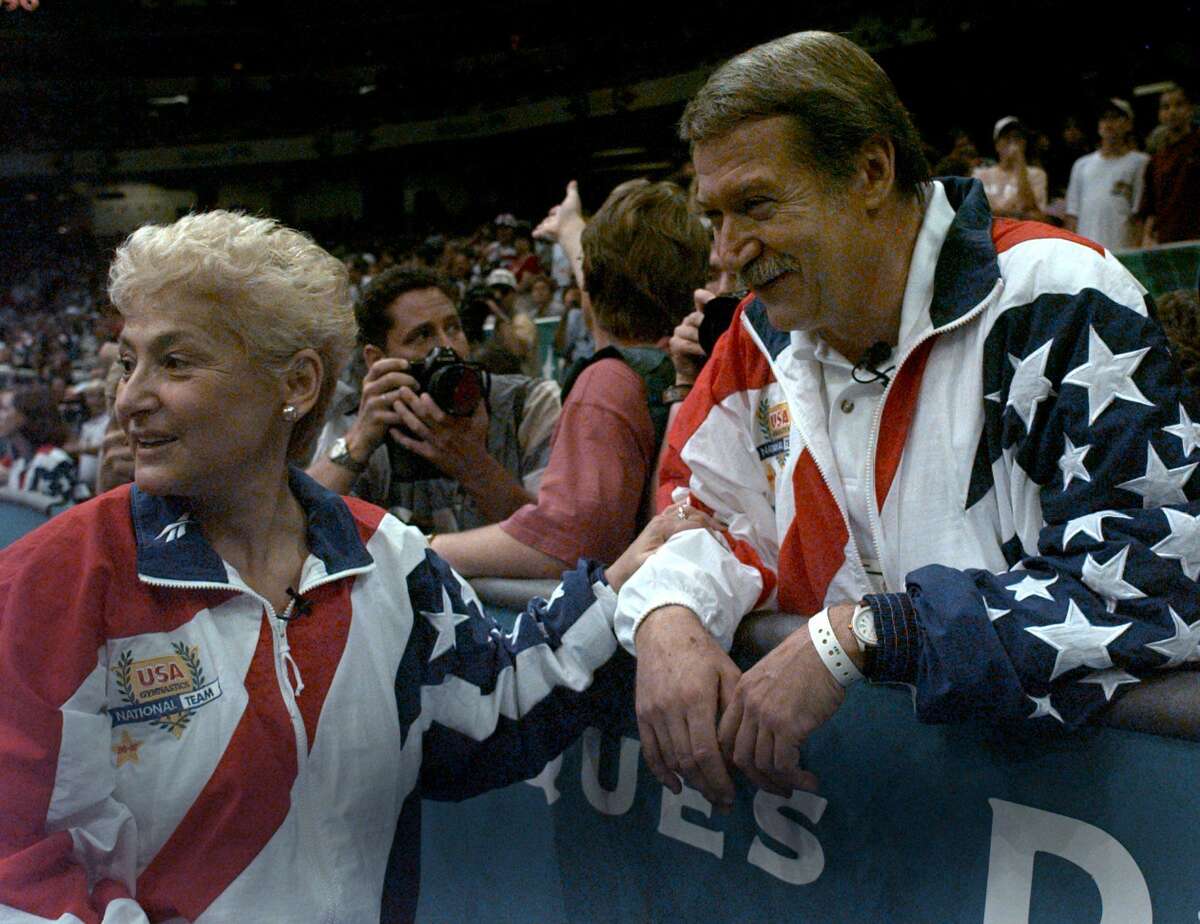 FILE - In this July 23, 2004, file photo, Martha and Bela Karolyi watch together as the U.S. womens gymnastic team celebrates winning the gold medal at the Centennial Summer Olympic Games in Atlanta. Victims of disgraced sports doctor Larry Nassar are imploring Texas authorities to investigate whether Bela and Martha Karolyi could have done more to prevent Nassar's sexual abuse at the couple's Texas training center. Five former gymnasts, including two who say Nassar abused them at the Karolyis' ranch near Huntsville, addressed reporters Thursday, May 10, 2018, outside state Attorney General Ken Paxton's office. (AP Photo/Amy Sancetta, File)