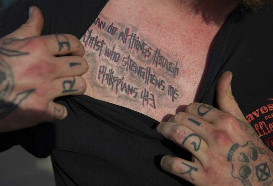 Cody Ledbetter, a former member of the Cossacks motorcycle club, shows the Bible verse he had tattooed on his chest to remember his stepfather, Danny Boyett, who was killed during a shoot out in the parking lot of a Twin Peaks restaurant on May 17, 2015. The verse was a favorite of Boyett and his wife, Nina. Photo taken Wednesday, April 18, 2018, in Waco.  ( Mark Mulligan / Houston Chronicle ) Photo: Mark Mulligan, Houston Chronicle / Houston Chronicle / © 2018 Houston Chronicle