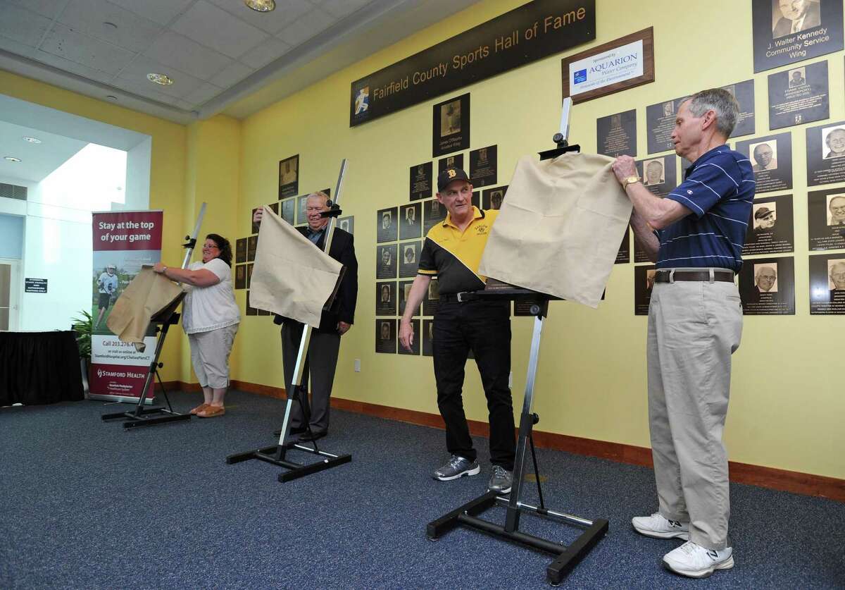 From right, Laddie Lawrence, Jim Dolan, Ralph King and Linda LaJoie Lay unveil the new plaques for the 2017 inductees into the Fairfield County Hall of Fame during a ceremony inside UConn Stamford in downtown Stamford, Conn. on Thursday, May 10, 2018. LaJoie Lay was representing her brother Randy LaJoie and Ralph King was represented former soccer player Phil Kydes, whom he coached in high school.