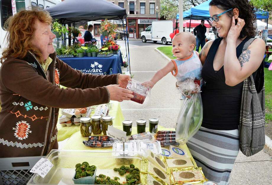Barbara Damin, left, of Damin Farms in St.Johnsville, shows some of their homemade red sauerkraut to an eager 8-month-old Emerson Rivera and his mom, Michelle Rivera of Schenectady, at the Downtown Farmers Market at City Hall Thursday May 10, 2018 in Schenectady,NY.  (John Carl D'Annibale/Times Union) Photo: John Carl D'Annibale