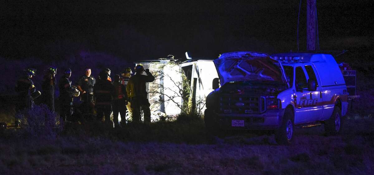 Laredo police officers and firefighters assess the scene of a fatal vehicle rollover early Friday, May 11, 2018 near the intersection of Mines and Iron Mine roads.