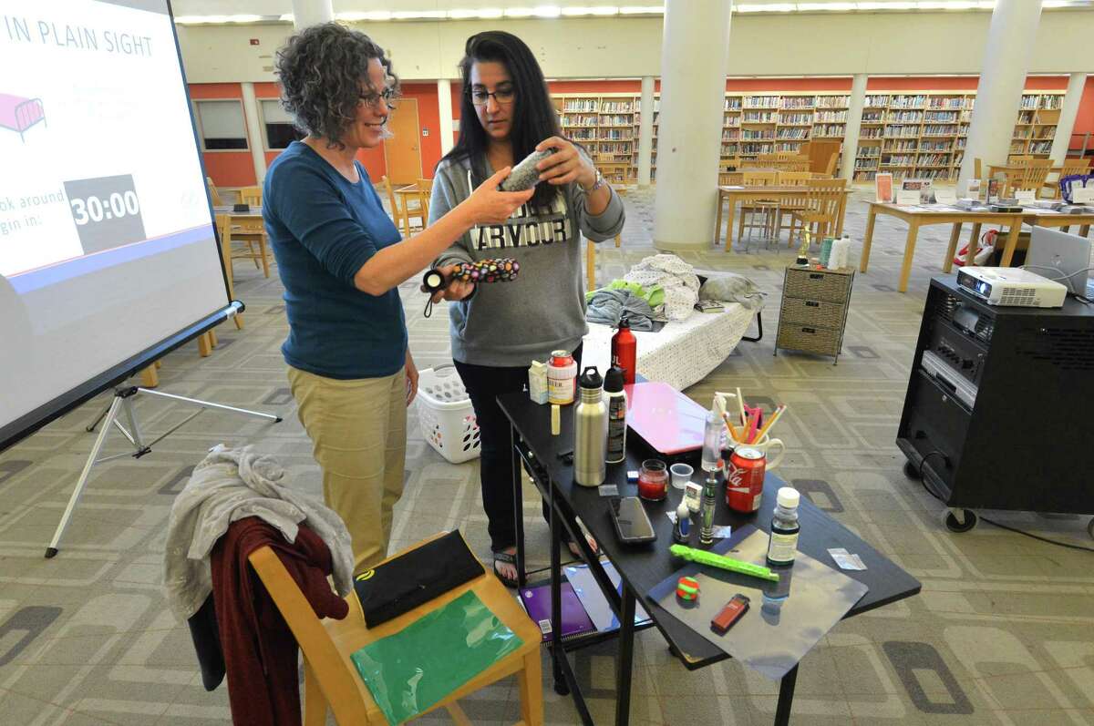 Margaret Watt and Deb Ryan find some of the items like a water bottle with a false bottom that are decoys planted in a mock bedroom with clues of high-risk behavior Thursday May 10, 2018 at Brien McMahon High School in Norwalk Conn. The workshop, ?“Hidden in Plain Sight,?” is hosted by Norwalk Public Schools, the Connecticut Association of Prevention Professionals, Positive Directions and the Human Services Council in light of National Prevention Week, which starts May 14.