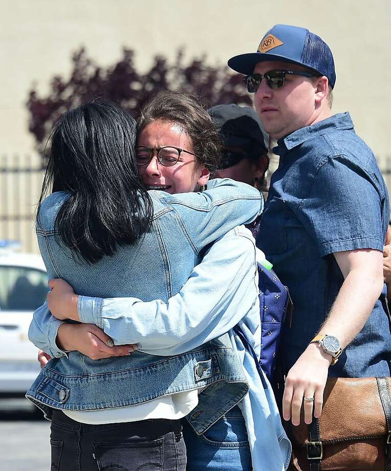 People embrace in front of the school on May 11, 2018 following reports of shooting at Highland High School in Palmdale, 40 miles (65 kilometers) north of downtown Los Angeles. Police arrested a man after reports of shootings at two schools near Los Angeles, the local sheriff's department and education officials said. The Los Angeles County Sheriff said one suspect had been detained "regarding the person with a gun" at Highland High School. Local news reports had earlier said that at least one person had been wounded. It was not immediately clear what type of weapon the man had.  Photo: FREDERIC J. BROWN, AFP/Getty Images