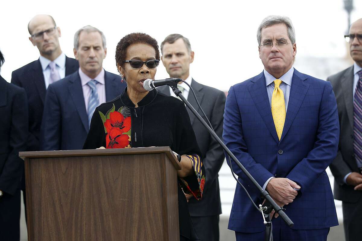 Oakland city attorney Barbara Parker (at podium) and SF city attorney Dennis Herrera (right) announce they had filed separate lawsuits on behalf of their respective cities against the five-largest investor-owned producers of fossil fuels on the Embardadero at Brannan streets on Wednesday, September 20, 2017, in San Francisco, Calif.