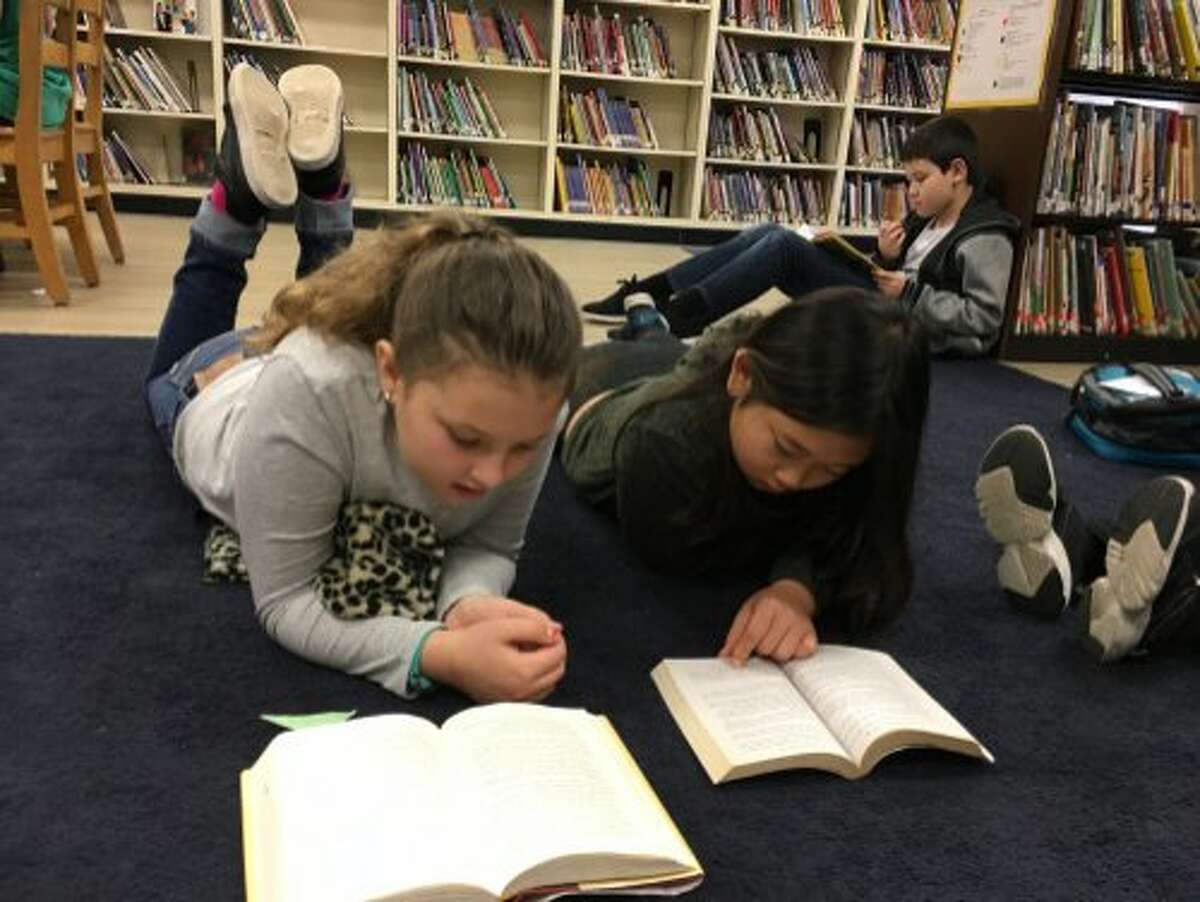 Students at Sequoia Elementary School in Oakland read on the carpet in the school's library. According to the Oakland Unified School District, 28.5 percent of the district's school libraries are closed.