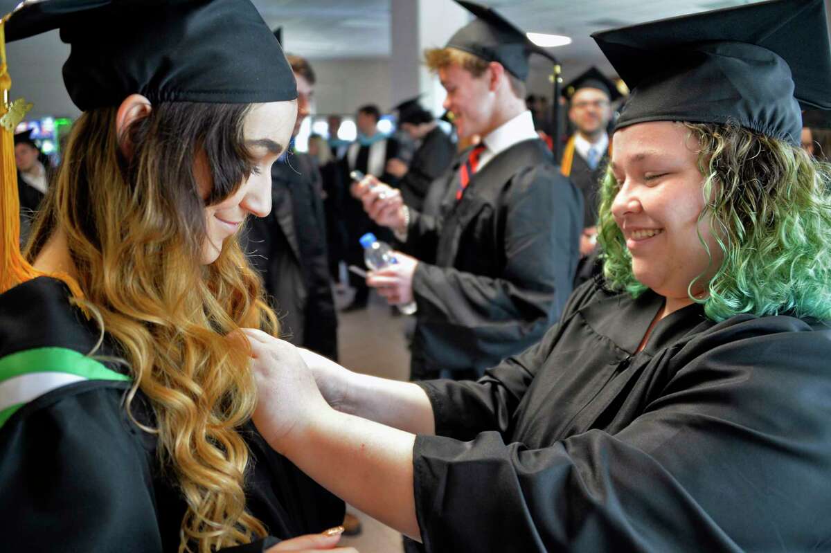 Hudson Valley Community College graduate Ember Sheffer, left, of Troy gets some help with her gown from classmate Emily Ellenbogen of Clifton Park before Commencement Saturday May 12, 2018 in Troy, NY. (John Carl D'Annibale/Times Union)