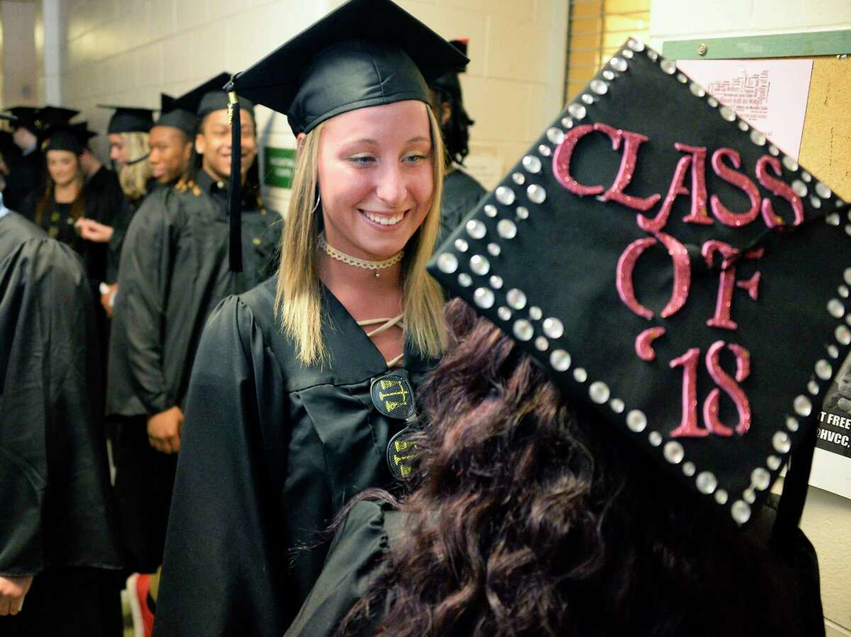 Hudson Valley Community College graduates Kali Szczepanski, center, of Watervliet and classmate Brittany Morris, under a Class of 2018 hat, of Brunswick wait for the start of Commencement Exercises Saturday May 12, 2018 in Troy, NY. (John Carl D'Annibale/Times Union)