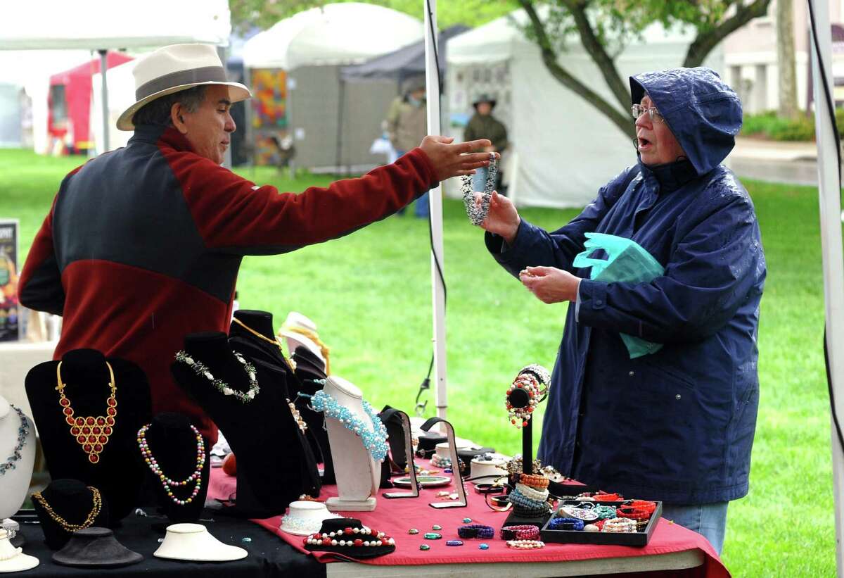 Antoinette Penkala looks at jewelry created by Jaime Blanch, who runs Pearl Shop from Watertown, MA at the annual Mother's Day Artisan Fair on the historic green in downtown Milford, Conn., on Saturday, May 12, 2018. The event featured as many as 100 artists offering handcrafted items, photography, jewelry and fine art as well as handcrafted apparel and food vendors. The market continues on Sunday from 11 a.m. - 4 p.m.