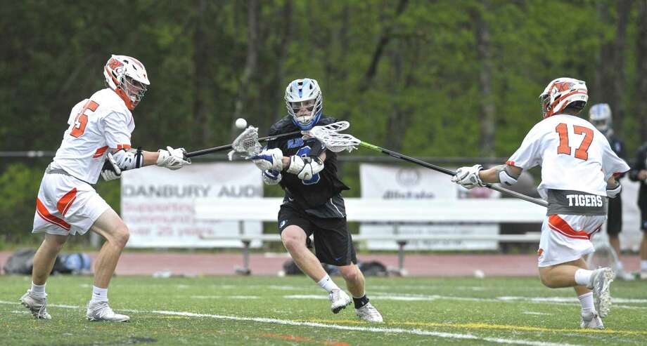 Darien's Hudson Pokorny (3) gets off a shot between Ridgefield's Jack Dowd (25) and Noah Iaacson (17) in the boys lacrosse game between Darien and Ridgefield high schools, Saturday afternoon, May 12, 2018, at Ridgefield High School, Ridgefield, Conn. Photo: H John Voorhees III / Hearst Connecticut Media / The News-Times