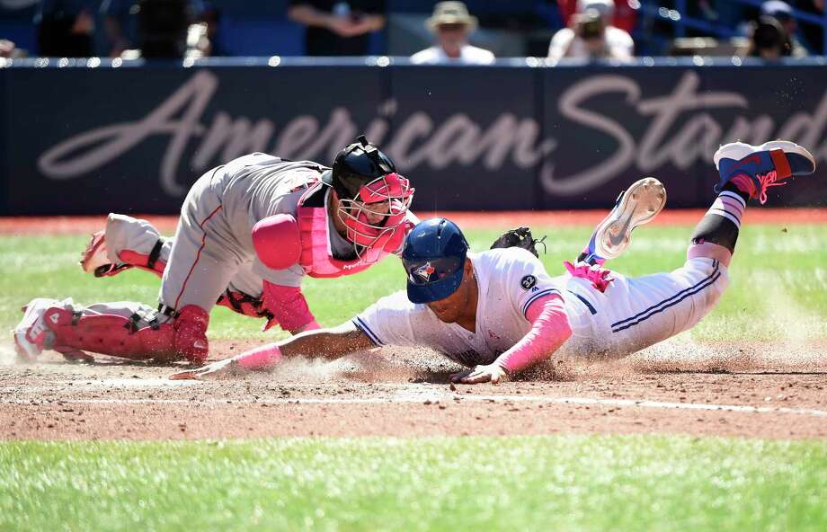 Toronto Blue Jays' Yangervis Solarte, foreground, is tagged out by Boston Red Sox catcher Christian Vazquez at home plate during seventh-inning baseball game action in Toronto, Sunday, May 13, 2018. (Nathan Denette/The Canadian Press via AP) Photo: Nathan Denette / The Canadian Press