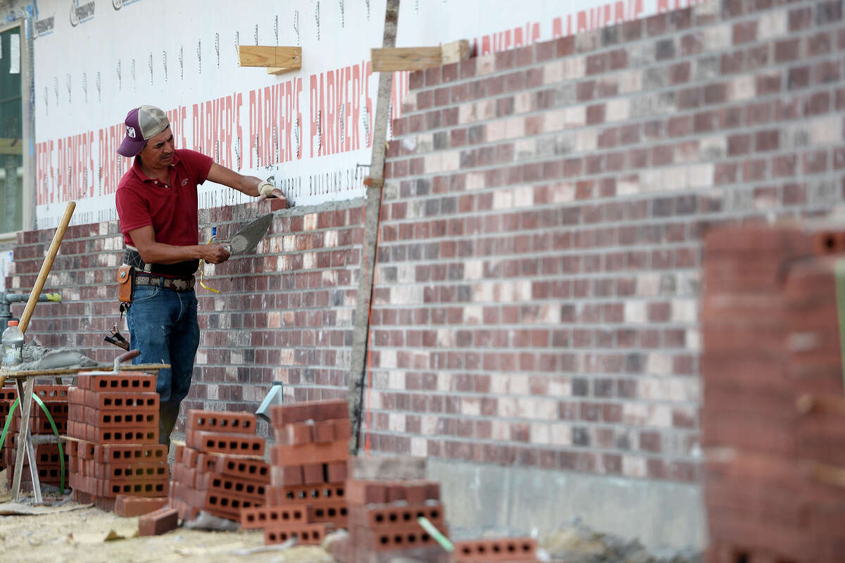 A mason works on the brick exterior wall of a house under construction in the Copper Point subdivision in Lumberton. Photo taken Friday 5/11/18 Ryan Pelham/The Enterprise