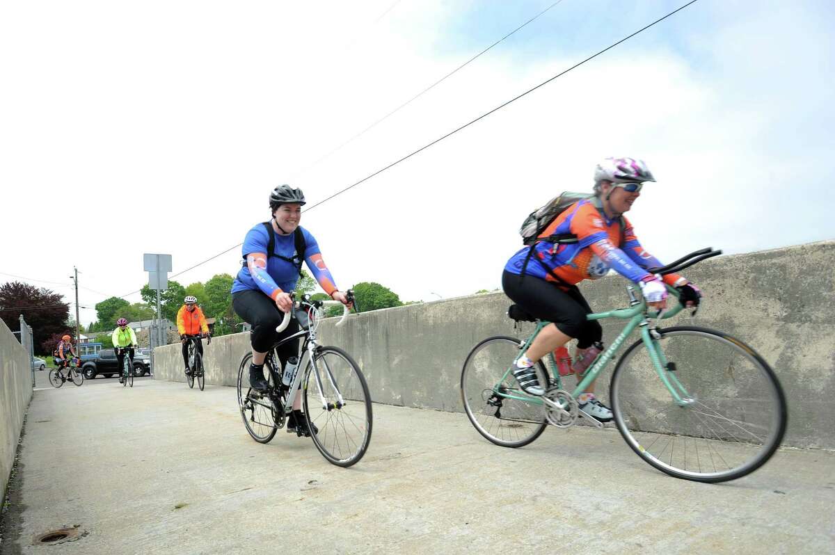 EMTs Kathleen Howard of Yonkers, N.Y. (center) and Nikki Deshensky of Harrison, N.Y. (right) enter Cove Island Park during a planned stop on the National EMS Memorial Bike Ride, which honors Emergency Medical Services personnel that died in the past year, in Stamford, Conn. on Monday, May 14, 2018. Howard and Deshensky were two of more than one hundred bicyclists that will make the approximately 500 mile journey from Boston, Mass. to National Harbord, Md.