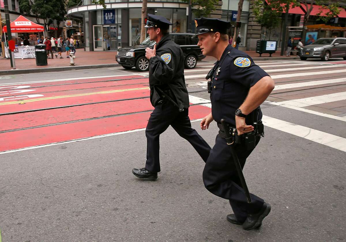 San Francisco police officers Roan, (left) and Doiron respond to a call along Market St. in San Francisco, Ca. on Mon. May 14, 2018.