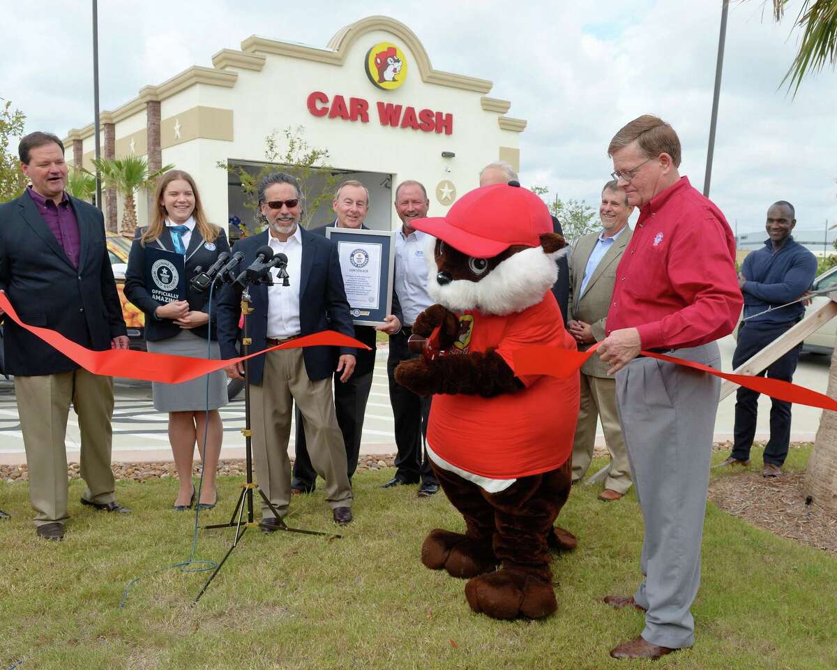Katy City Council Member Steve Pierson assists Buc-ee the Beaver as he cuts a ribbon at the ceremony designating the car wash at the Katy Buc-ees as a Guinness World Record in length on November 16, 2017.
