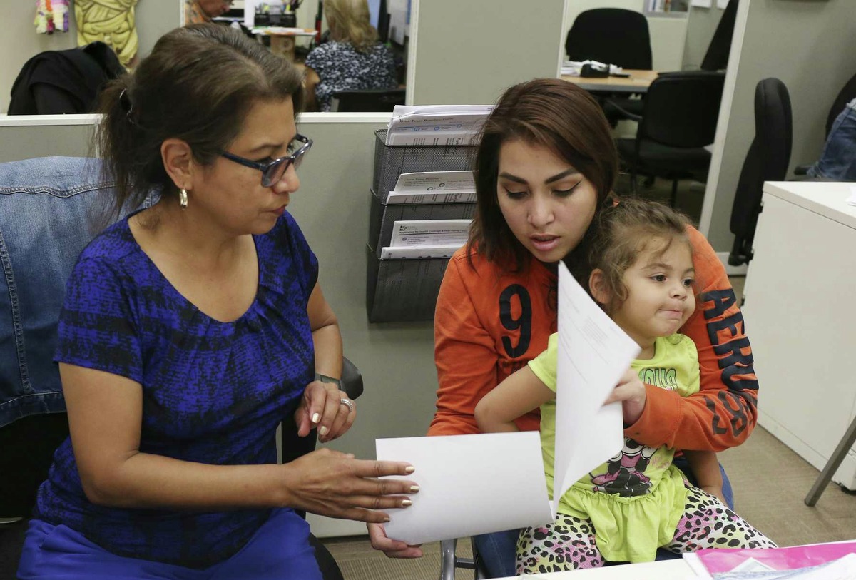 Twenty-two-year-old Sky Gomez holds her daughter, Gisselle Metoyer, 3, as she gets help renewing her Supplemental Nutrition Assistance Program benefits from Annie Gonzales, Client Service Representative at the San Antonio Food Bank, Monday, May 14, 2018. Texas administers over $410 million in SNAP benefits each month, mostly to low-income children and families. The program, formerly known as food stamps, is funded entirely by federal dollars.