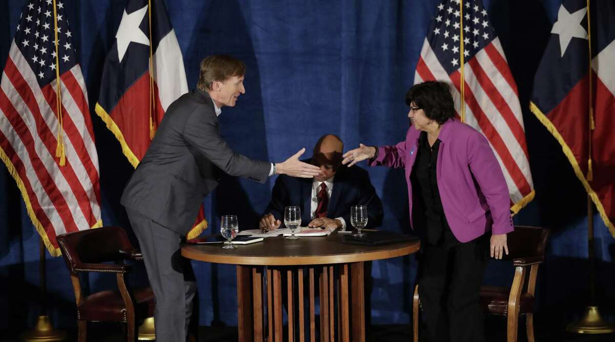 Texas Democratic gubernatorial candidates Andrew White, left, and Lupe Valdez, right, shake hands following their debate, Friday, May 11, 2018, in Austin, Texas, ahead of the state's May 22 primary runoff election. Moderator Gromer Jeffers is at center. (AP Photo/Eric Gay)