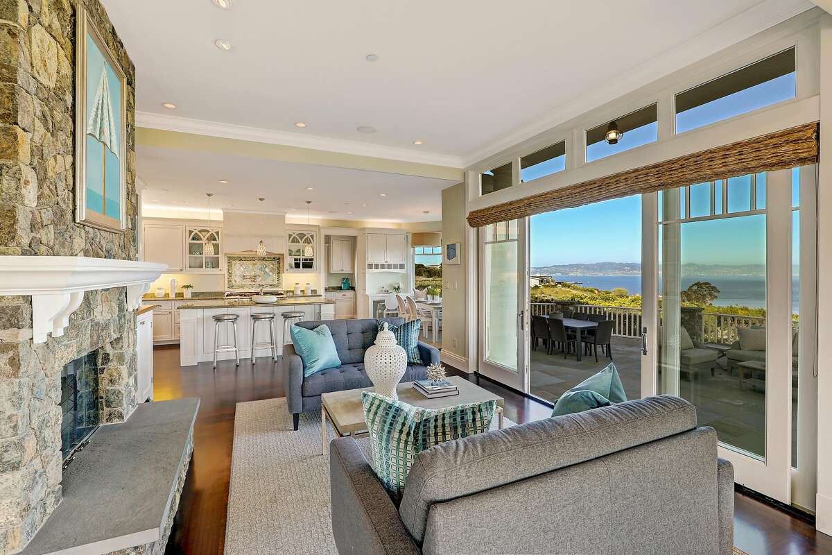 The family room features a stone fireplace and access to a terrace with bay views.�
