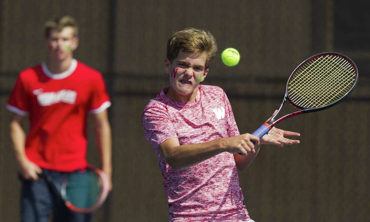 Garrett Skelly of The Woodlands returns a hit in front of Hunter Bajoit during the District 12-6A tennis tournament at The Woodlands High School, Thursday, April 5, 2018, in The Woodlands.