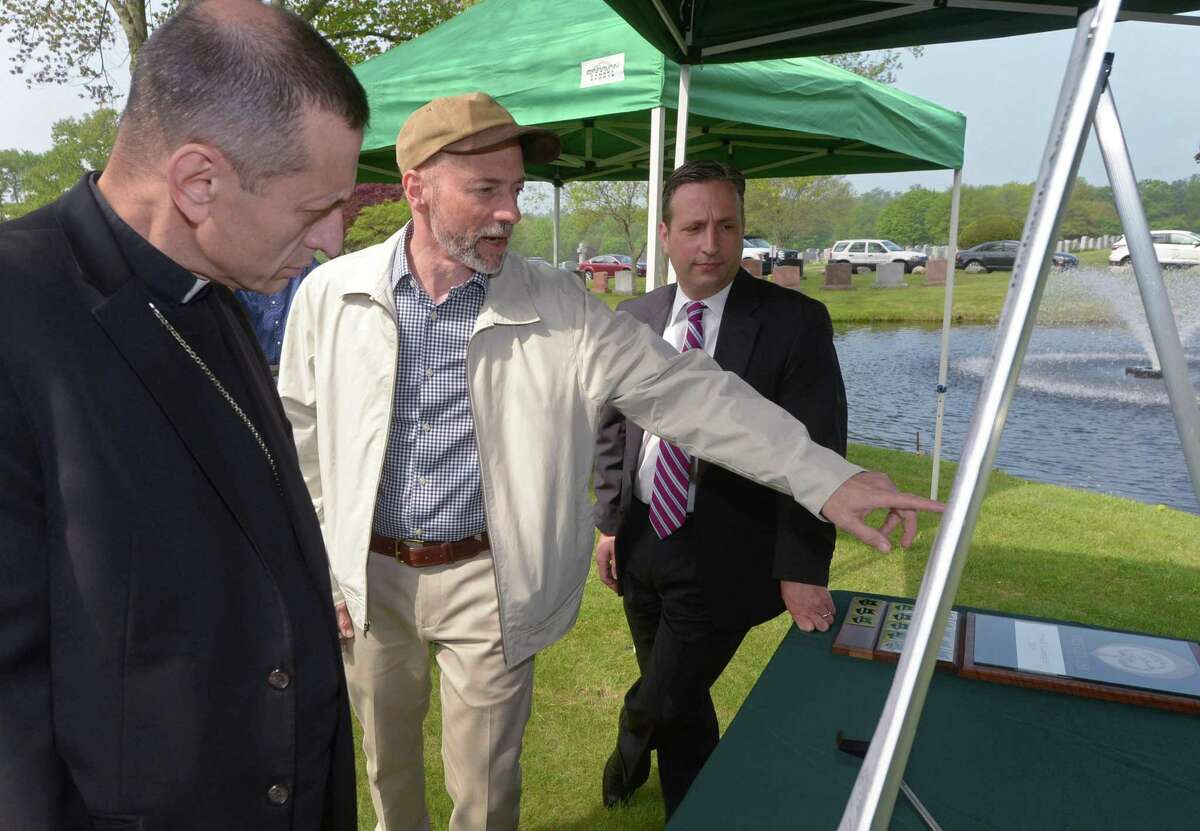 Bishop Frank Caggiano of the the Diocese of Bridgeport, Peter Viteretto of the Tree Advisory Committee and State Senate Majority Leader Bob Duff look at a landscape drawing as The Norwalk Tree Advisory Committee and the Diocese of Bridgeport conduct a dedication ceremony for the initial planting of the tree canopy at St. John?’s Cemetery along Richards Ave. Tuesday, May 15, 2018, in Norwalk, Conn.
