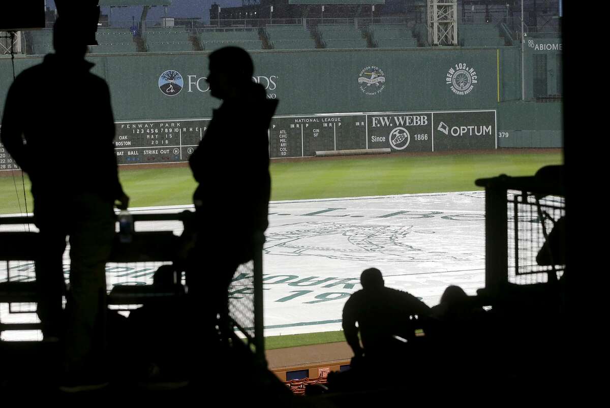 People wait in the stands during a rain delay at Fenway Park before a scheduled baseball game between the Oakland Athletics and the Boston Red Sox, Tuesday, May 15, 2018, in Boston. (AP Photo/Steven Senne)