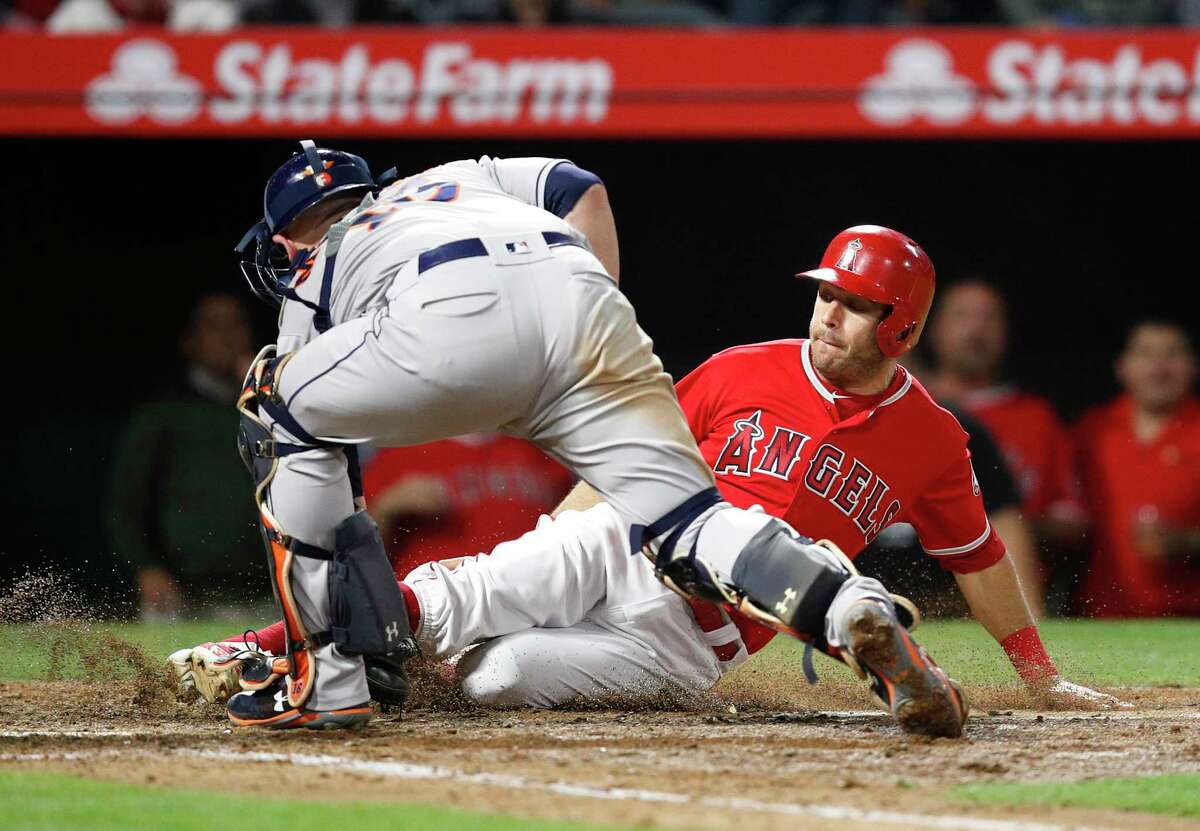 Los Angeles Angels' Ian Kinsler, right, is tagged out by Houston Astros catcher Brian McCann while trying to score on a single by Kole Calhoun during the seventh inning of a baseball game Tuesday, May 15, 2018, in Anaheim, Calif. (AP Photo/Jae C. Hong)