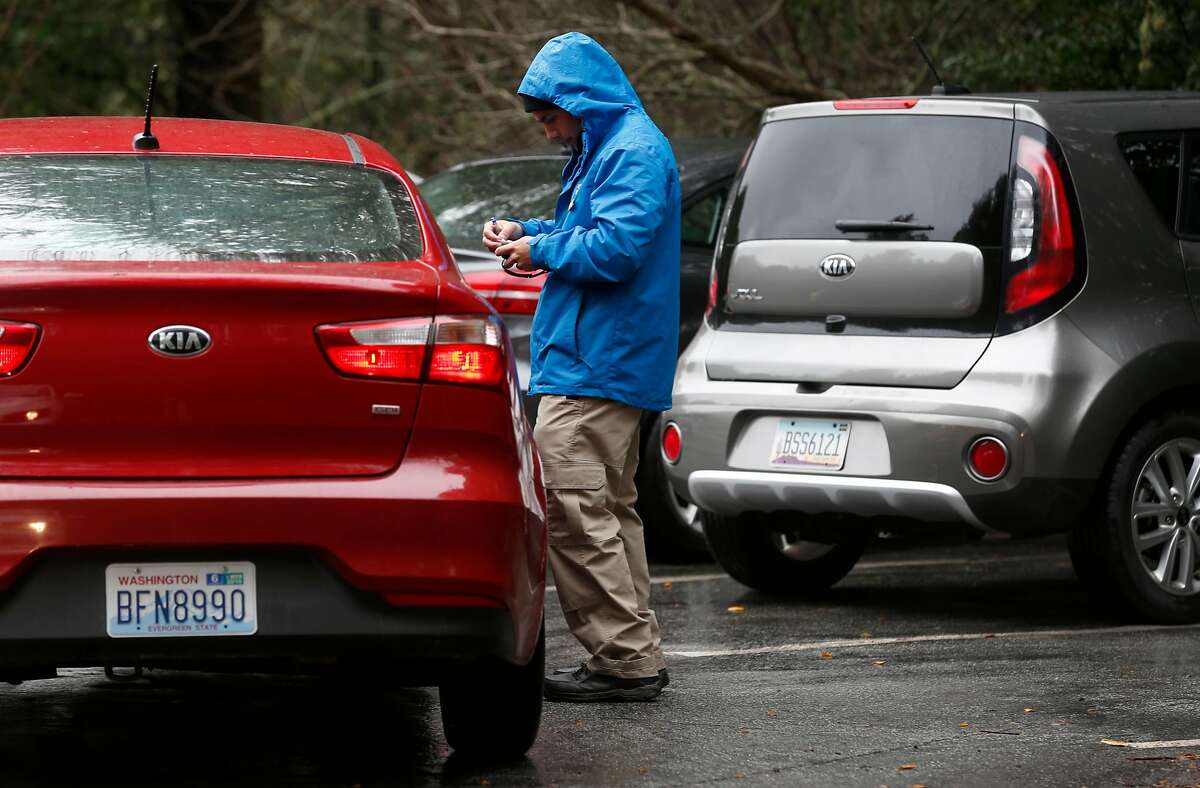 A parking �ambassador� assists a visitor arriving on the first day of a reserved parking system at Muir Woods National Monument in Mill Valley, Calif. on Tuesday, Jan. 16, 2018. Due to the lack of cellphone coverage at the park, visitors arriving without parking permits were instructed to drive up to the top of the hill at Panoramic Highway and use their mobile devices to purchase permits online before returning.