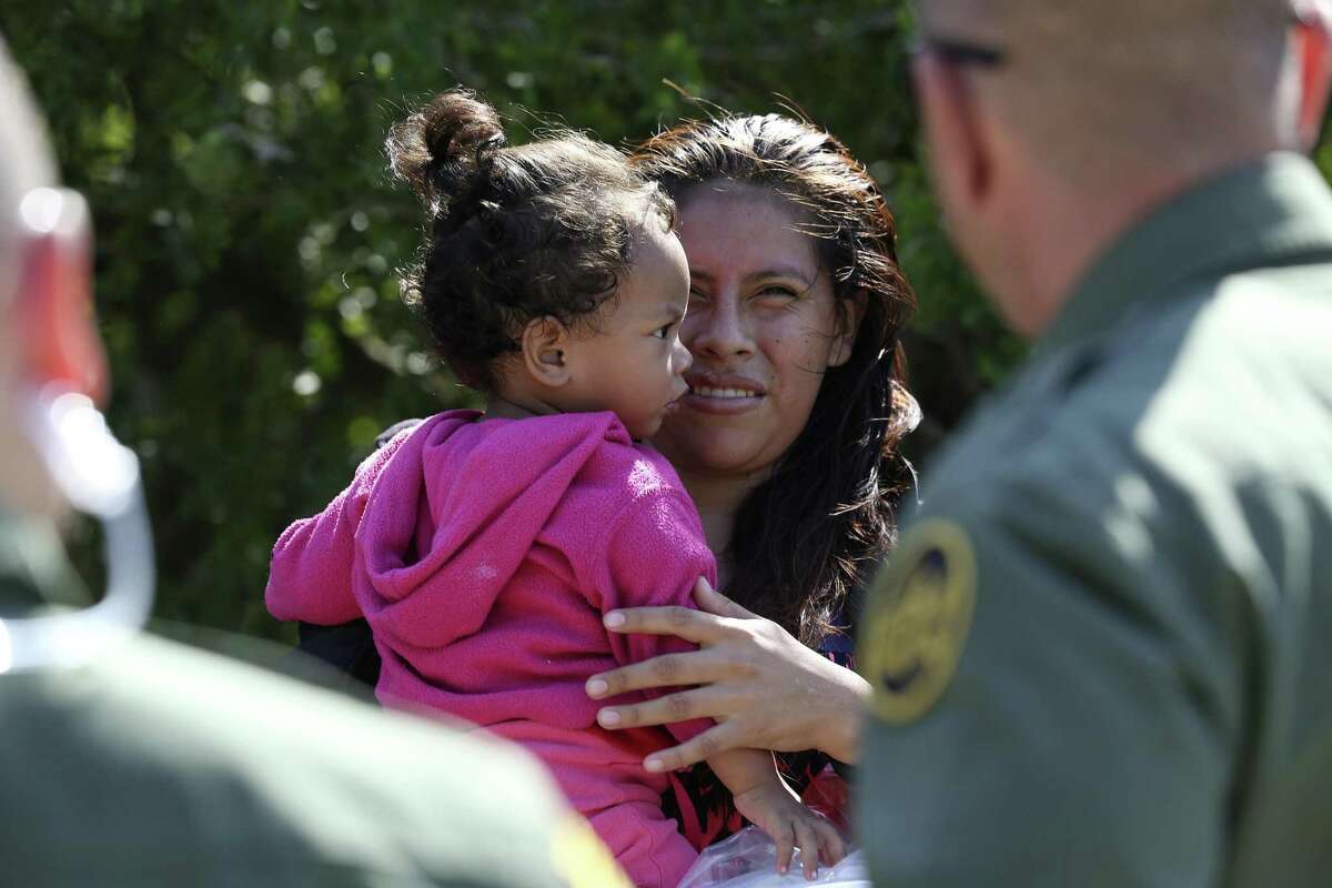 Honduran Patricia Rodriguez Hernandez, 22, holds her daughter, Denia Abigail, 1, after surrendering to U.S. Border Patrol agents near the Anzalduas International Bridge in Mission.