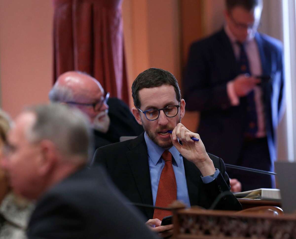 State Sen. Scott Wiener checks his mobile phone after state Sen. Tony Mendoza tendered his resignation at the State Capitol in Sacramento, Calif. on Thursday, Feb. 22, 2018 following allegations of sexual misconduct.