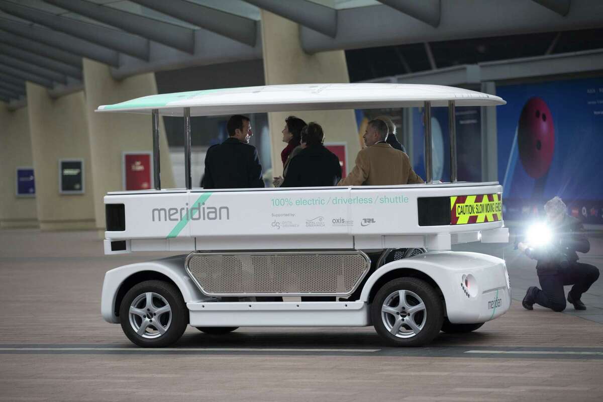 Dignitaries try out a prototype driverless car called a Meridian shuttle during a launch event for the media near the O2 Arena in London, Wednesday, Feb. 11, 2015. Britain has begun testing driverless cars in four cities, launching the first official trials ahead of a series of planned rule reviews to accommodate the new technology. (AP Photo/Matt Dunham)