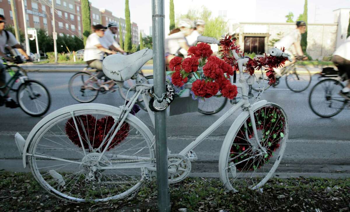 Area cyclist ride past a ghost bike dedicated to Chelsea Norman, who was killed by a driver while riding her bike in 2013, during a 10-mile route in silence on Wednesday, May 16, 2018 in Houston. The riders were joining other cyclists worldwide in the "Ride of Silence" to bring attention to those who have died while riding their bicycles on local roads.