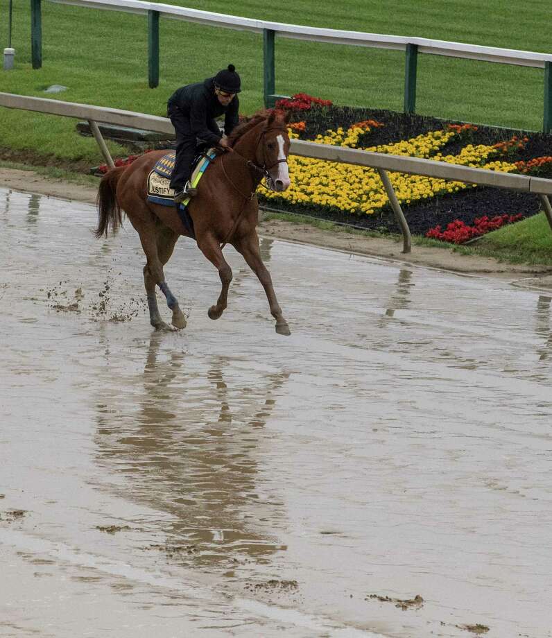 Kentucky Derby winner Justify gallops over the muddy track for his morning exercise at Pimlico Race Course in preparation for Saturday's Preakness Stakes Thursday May 17, 2018 in Baltimore, MD (Skip Dickstein/Times Union) Photo: SKIP DICKSTEIN, Albany Times Union