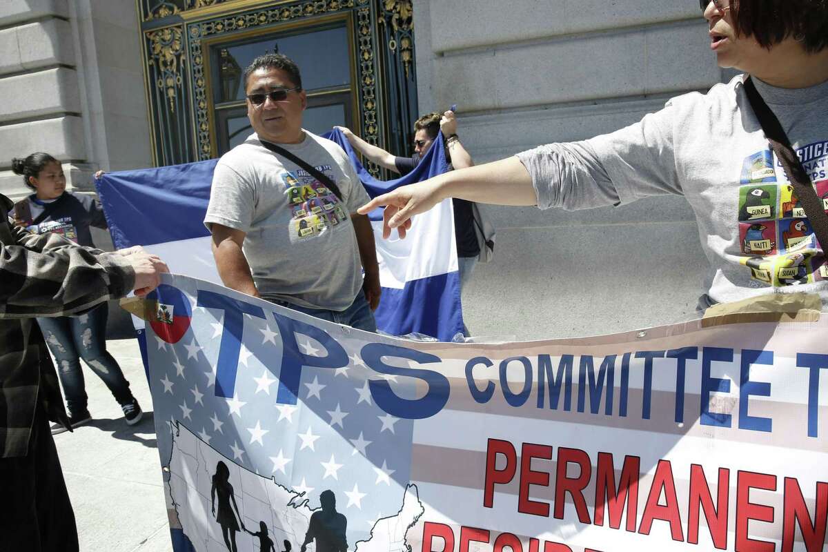 Victor Diaz, (left center) a temporary protected status holder, joins the news conference and rally on the steps of City Hall in San Francisco, Ca. on Mon. May 7, 2018, to criticize the Trump Administration decision to end a program that has protected tens of thousands of Hondurans in the U.S. from deportation. Diaz has been in the US since 1992.