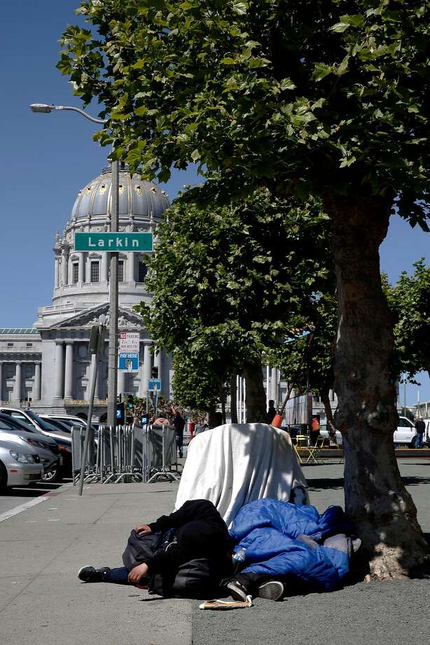 people sleep on the sidewalk near city hall.
